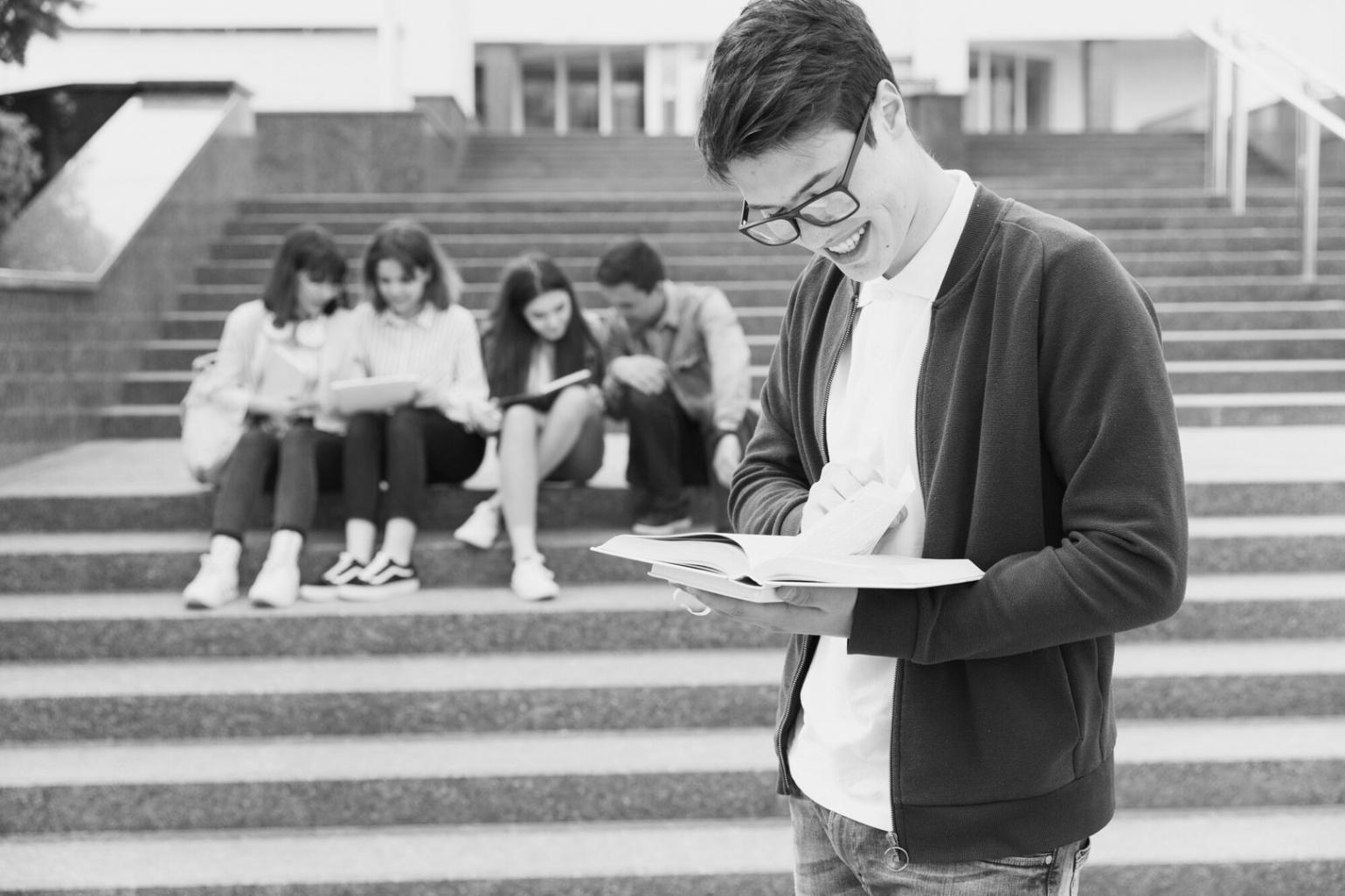 Estudiante aplicando conceptos financieros en laptop con gráficos de presupuesto